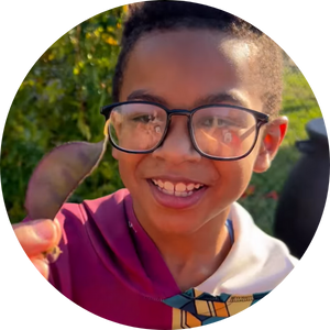  boy wearing glasses holding bean pod